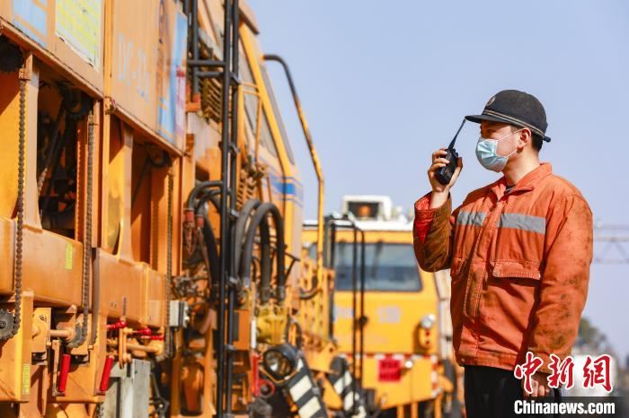 工人正在指挥大型养路机械车辆进行施工作业。　汪翰 摄