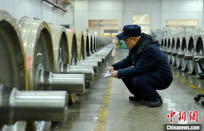 生产车间里工人师傅正在核对每一根车轴编号。 刘忠俊 摄 生产车间里工人师傅正在核对每一根车轴编号。 刘忠俊 摄