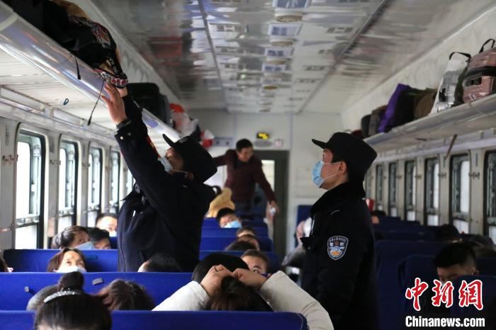 乘警李章龙带着“徒弟”在车厢排查安全隐患。 郝黎俊 摄 乘警李章龙带着“徒弟”在车厢排查安全隐患。 郝黎俊 摄